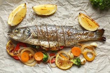 Tasty fish with grilled vegetables and lemon on parchment