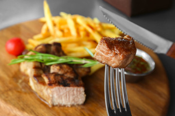Eating of delicious juicy steak at restaurant, closeup