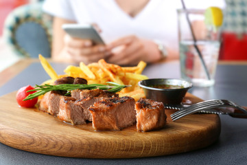 Composition of sliced juicy steak with rosemary on wooden board