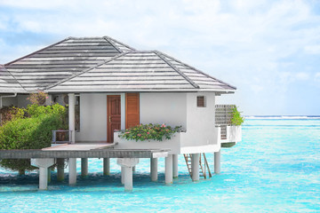 View of modern beach house on piles at tropical resort