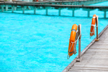 Fototapeta premium Wooden pontoon with flotation rings at sea resort