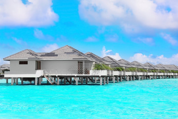 Fototapeta na wymiar Modern beach houses on piles at tropical resort