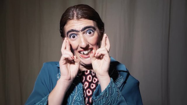 A funny ugly woman wishfully crossing her fingers.
