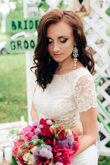 Bride in a beautiful dress in the decor in a summer park