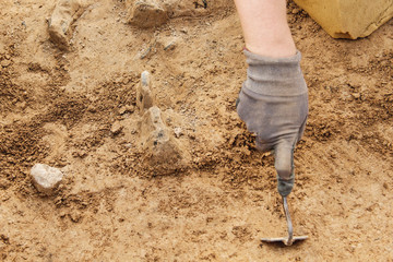 Archeological tools, Archeologist working on site, hand and tool.