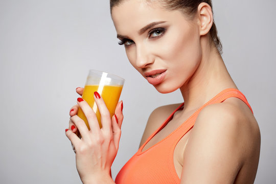 Beautiful woman holding a glass of orange juice. Healthy diet