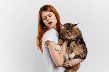 Beautiful young woman on white isolated background holds a cat