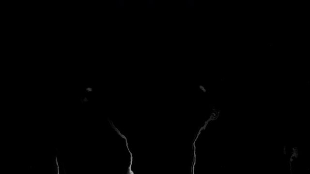 Black ink flowing on white background