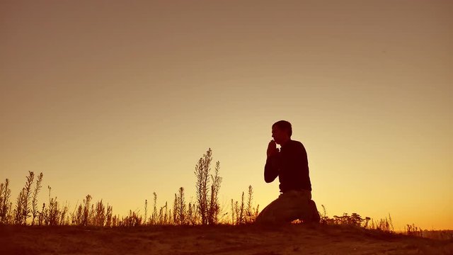 Silhouette illustration of man praying outside at beautiful landscape