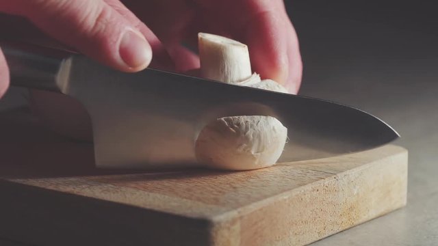 chef cutting a mushroom and garlic close up with nice lighting 