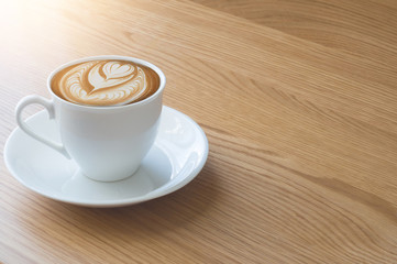 A cup of coffee and notebook on wood table . Coffee break in morning ,break working  / selective focus.Blank seating  indoor in living room .copy space for create idea for business.