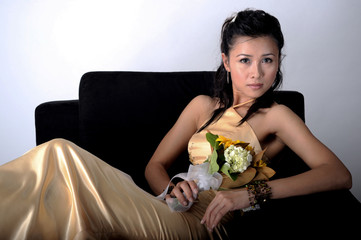 Studio shot of a pretty Asian girl in gold color dress