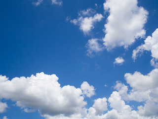 Vast blue sky background with white fluffy clouds