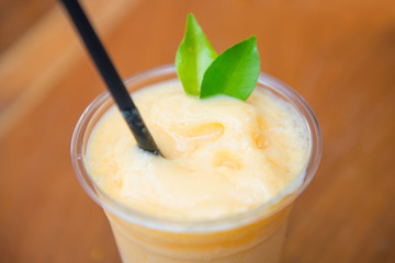 Sweet mango smoothie in plastic cup