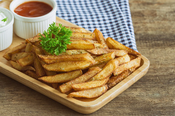 Homemade french fries serve with ketchup and sour cream or mayonnaise. Golden brown crispy french fries sprinkle with salt and oregano on wood plate for snack or appetizer. French fries on wood table.