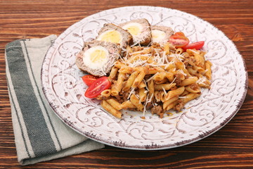 Boiled eggs in a layer of sausage meat wrapped with pasta