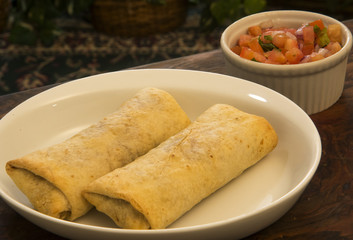 two chimichana with a side of salsa