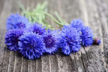 Cornflower blue flowers (Centaurea cyanus) on an old wooden table