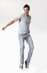 full length picture of casual young man posing on white background