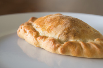 golden hot pasty on a white plate