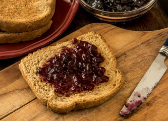 wheat toast with grape jam on a cutting board