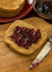 wheat toast with grape jam on a cutting board