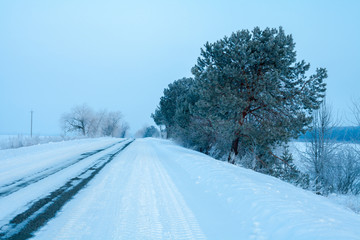 Obraz premium Snowy winter road in the early morning