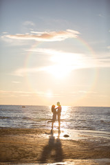 Fototapeta premium A young couple in love, on the shore of the Bay at sunset