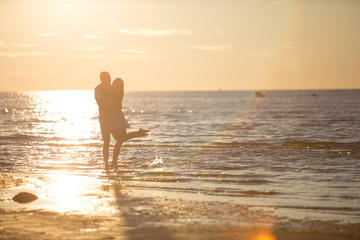 A young couple in love, on the shore of the Bay at sunset