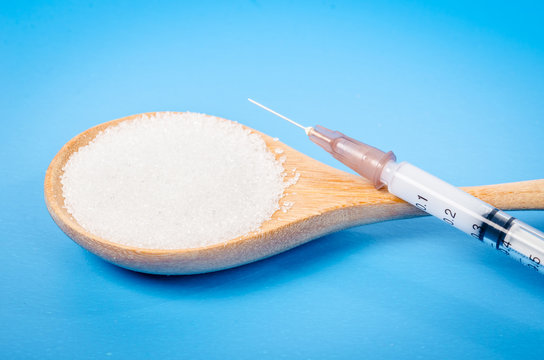 insulin in syringe and white sugar.