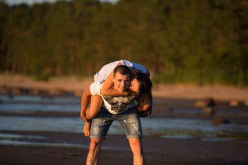 A young couple in love, on the shore of the Bay at sunset