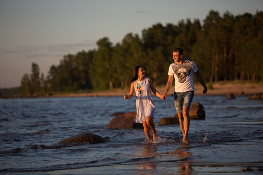 A young couple in love, on the shore of the Bay at sunset