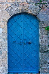 Blue arch ancient iron castle door with stone lintel