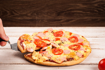 Hot pizza slice with melting cheese on a rustic wooden table