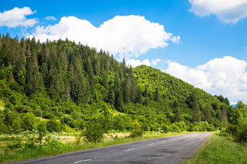 Mountain road in summer. Beautiful landscape hill forest and blue sky.