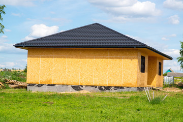 frame country house  lined with osb plates with brown roof made of metal