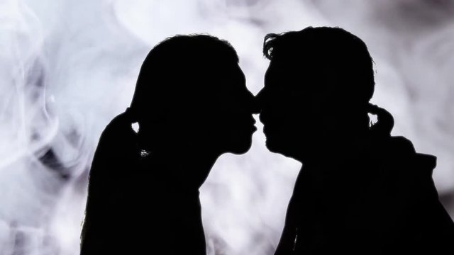 The smokey silhouettes of a man and a woman kissing with fondness and passion. Love, lovers, Valentine.
