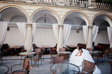 Portrait of a fabulous bride posing by herself with breathtaking architecture on the background.