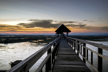 A beautiful twilight on a wooden bridge stretching to the lake
