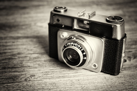 Old vintage retro camera on wooden background