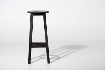 Studio shot of classic black tall wooden barstool standing on white