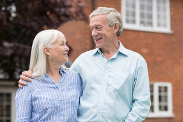 Retired Couple Standing Outside Home