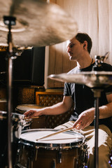 Man drummer playing drums in recording studio. Rehearsal before live music concert