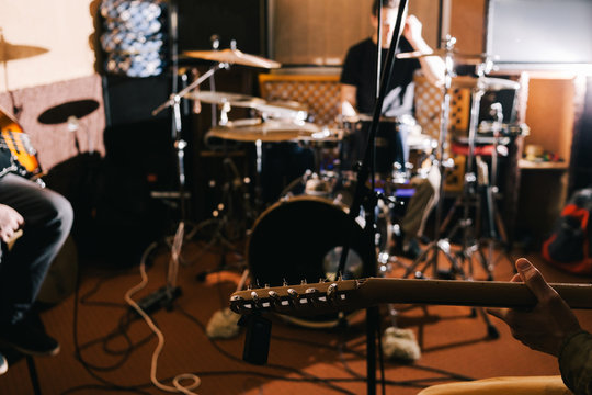 Electric guitar riff closeup. Guitarist in studio, music band recording process, blurred background