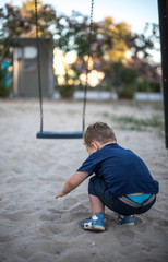 Little cute boy playing with a sand.in children playground