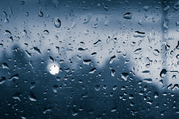 Background, wet fogged glass film with drops of water and dew during the rain at sunset