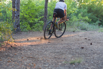 Young athlete riding on his professional mountain or cyclocross bike in the forest 