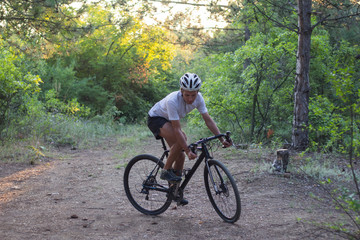 Young athlete riding on his professional mountain or cyclocross bike in the forest 