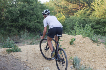 Obraz premium Young man riding up hill on his professional bicycle 