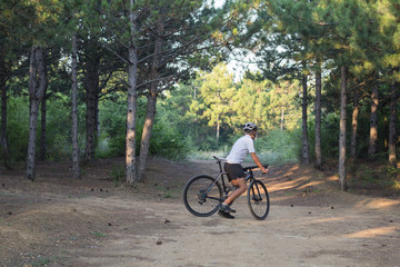 Young athlete riding on his professional mountain or cyclocross bike in the forest 